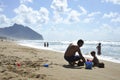 Father and son playing on the beach at the sunset time. Concept of friendly family