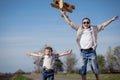 Father and son playing with cardboard toy airplane in the park a Royalty Free Stock Photo