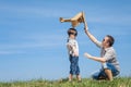 Father and son playing with cardboard toy airplane in the park a Royalty Free Stock Photo