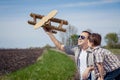 Father and son playing with cardboard toy airplane in the park a Royalty Free Stock Photo