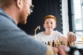 father and son playing chess and looking at each other Royalty Free Stock Photo