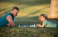 Father and son playing chess lying on grass at lawn park. Fathers Day, love family, parenthood, childhood concept Royalty Free Stock Photo