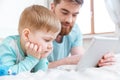 Father and son playing computer games on tablet at home Royalty Free Stock Photo