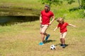 Father and son playing football in park. Dad and little boy play soccer. Sporty family enjoy summer day. Sport for kids Royalty Free Stock Photo