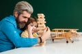 Father and son playing jenga game at home. Elementary school and education. Cute pupil and his father schooling work. Royalty Free Stock Photo