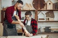 Father and son playing knights with wooden DIY swords at carpenter workshop Royalty Free Stock Photo