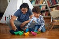 Father and son playing with paper boats on the floor at home. Family, together, love, playtime