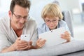 Father and son playing with smartphone and tablet Royalty Free Stock Photo