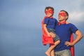 Father and son playing superhero outdoors at the day time.