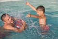 Father and son playing in the swimming pool at the day time. Royalty Free Stock Photo