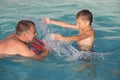 Father and son playing in the swimming pool at the day time. Royalty Free Stock Photo