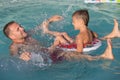 Father and son playing in the swimming pool at the day time. Royalty Free Stock Photo