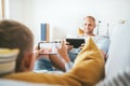 Father and son playing with tablet and gamepad sitting in livin Royalty Free Stock Photo