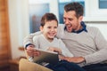 Father and son playing on a tablet at home Royalty Free Stock Photo