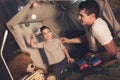 Father and son are playing with toy airplane and cars at night at home.