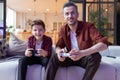 Father and son playing video game in living room Royalty Free Stock Photo