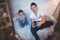 Father and son are playing video games on tv at night at home. Royalty Free Stock Photo