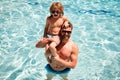 Father and son in pool. Family having fun on summer vacation. Pool party. Child with dad playing in swimmingpool.