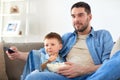 Father and son with popcorn watching tv at home Royalty Free Stock Photo