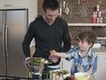 Father And Son Preparing Salad At Kitchen Counter Royalty Free Stock Photo
