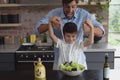 Father and son preparing vegetable salad in kitchen Royalty Free Stock Photo
