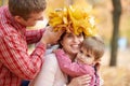 Father and son put yellow fallen leaves on mother head. Happy family is in autumn city park. Children and parents. They posing, Royalty Free Stock Photo