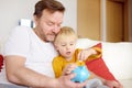 Father and son putting coin into piggy bank. Education of children in financial literacy