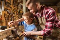 Father and son with rasp working at workshop