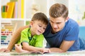 Father and son read together sitting on the floor Royalty Free Stock Photo