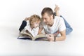 Father and son are reading a book on the floor