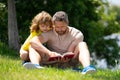 Father and son reading a book in park. The concept of education and friendship. Lifestyle, father read a book to his Royalty Free Stock Photo