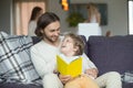 Father and son reading book sitting on sofa at home Royalty Free Stock Photo
