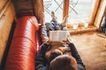 Father and son reading book together lying on the cozy sofa in warm country house. Reading to kids top view concept image Royalty Free Stock Photo