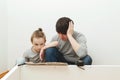 Father and son reading the instructions to assemble furniture in new home. Do it yourself furniture assembly Royalty Free Stock Photo