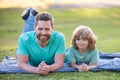 Father and son relaxing on nature in park. Concept of children and parents, happy family. Royalty Free Stock Photo