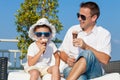Father and son relaxing near a swimming pool at the day time. Royalty Free Stock Photo