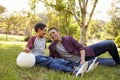 Father and son relaxing with soccer ball in a park, close up Royalty Free Stock Photo
