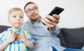 Father and son with remote watching tv at home Royalty Free Stock Photo