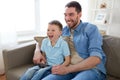 Father and son with remote watching tv at home Royalty Free Stock Photo