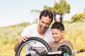 Father and son repairing bike together