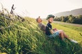 Father and son rest in high green grass after bicycle walk