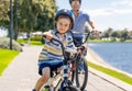 Father and son riding their bikes having fun together in the park by the lake Royalty Free Stock Photo