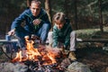 Father and son roast the mashmallow candies on the camp fire Royalty Free Stock Photo