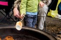 Father and son roasting large marshmallow on a stick over the campfire firepit. Camping family fun