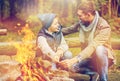 Father and son roasting marshmallow over campfire Royalty Free Stock Photo