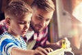 Father and son with ruler measure wood at workshop