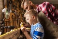 Father and son with ruler measure wood at workshop