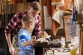 Father and son with ruler measure wood at workshop