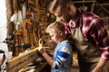 Father and son with ruler measure wood at workshop