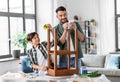 father and son with ruler measuring old table